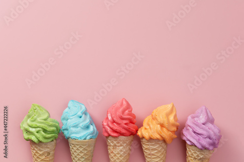 Various of colourful meringue ice cream cone on pink background for sweet and refreshing dessert concept