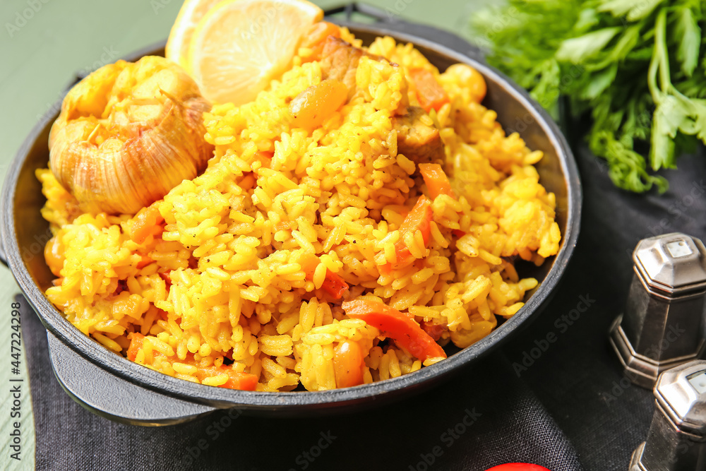 Frying pan with tasty pilaf on table, closeup Frying pan with tasty pilaf on table, closeup
