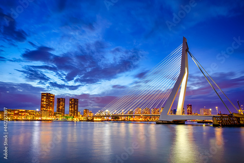 Netherlands Travel Concepts. Tranquil Night View of Renowned Erasmusbrug (Swan Bridge) in Rotterdam in Front of Port with Harbour. Shoot Made At Dusk.