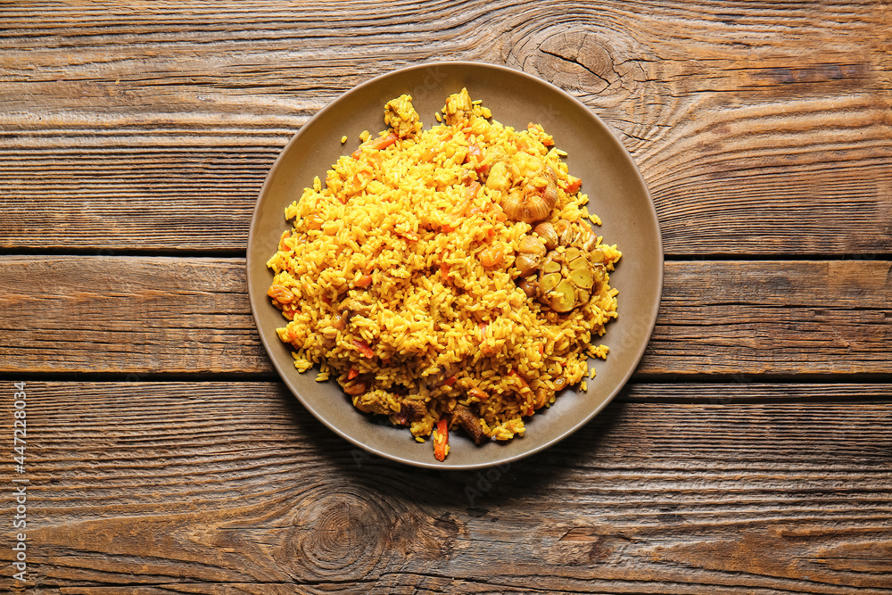 Plate with tasty pilaf on wooden background Plate with tasty pilaf on wooden background