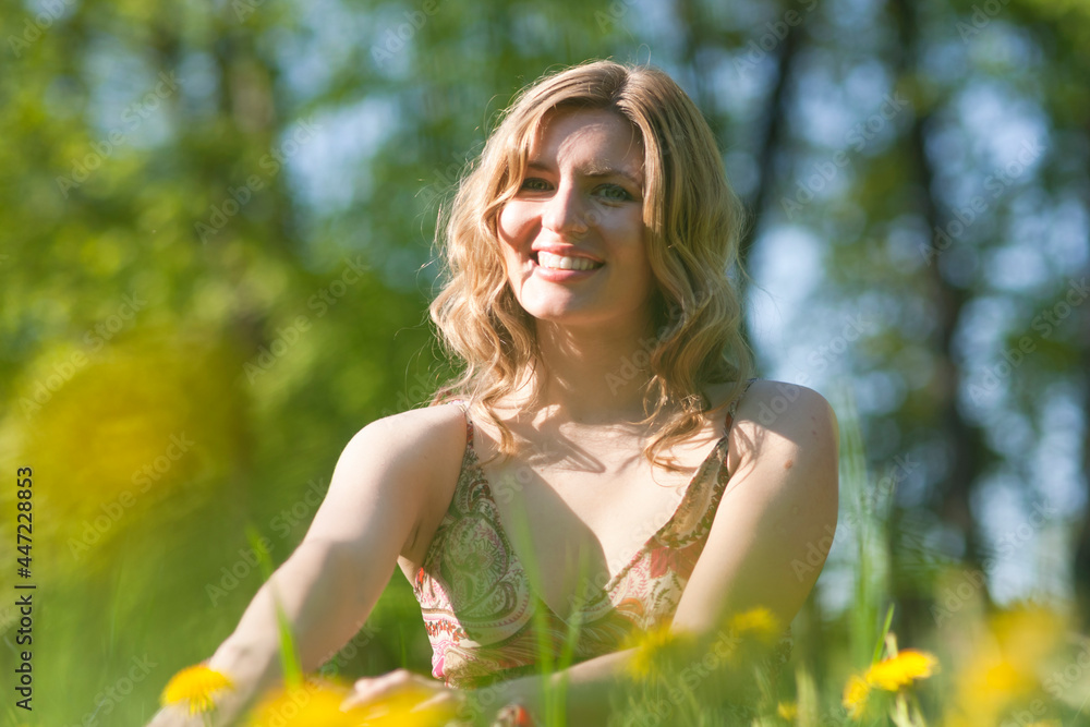 Young Woman Blond Female Summertime Resting on Green Meadow Outdoors With Positive Expression. Young Woman Blond Female Summertime Resting on Green Meadow Outdoors With Positive Expression.