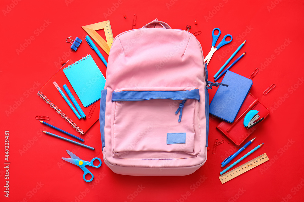 School backpack and stationery on color background School backpack and stationery on color background