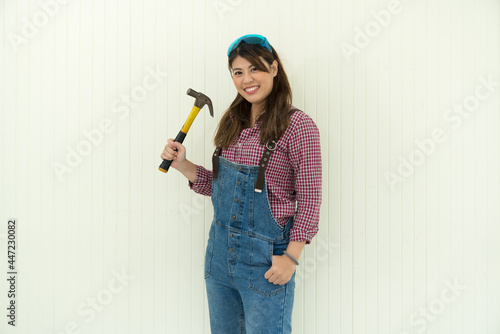 Females carpenter holding a hammer near white background