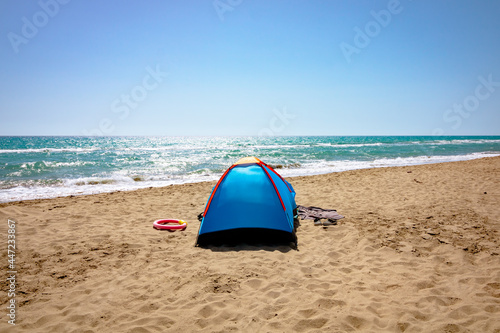 A blue tent on the beach. Camping near the sea. Camping in summer.