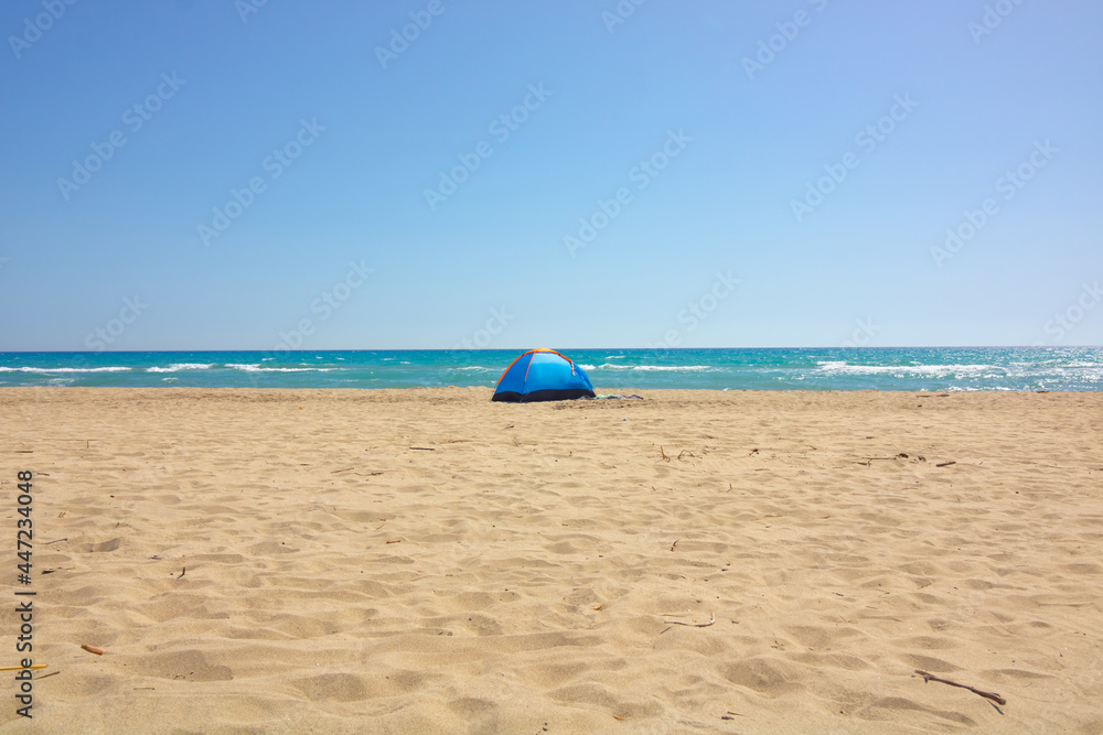 A blue tent on the beach. Camping near the sea. Camping in summer. A blue tent on the beach. Camping near the sea. Camping in summer.