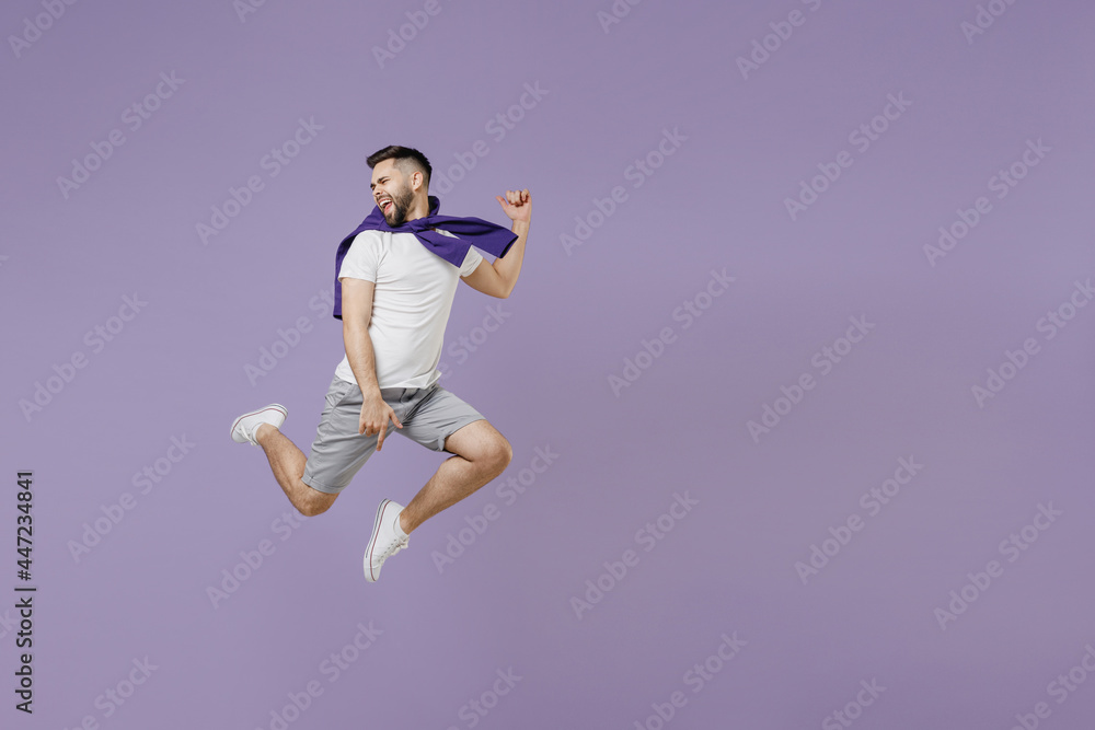 Full size body length young brunet man 20s wear white t-shirt purple shirt jump like dancing keep eyes closed head aside isolated on pastel violet background studio portrait. People emotions concept.