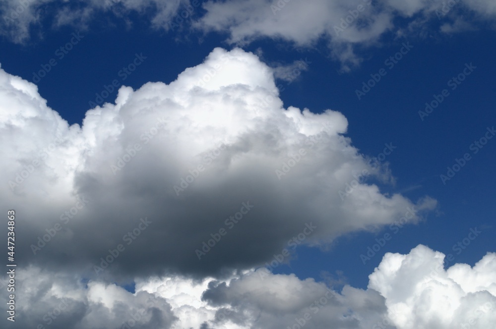 Obraz premium White clouds in a bright blue sky. A sunny day