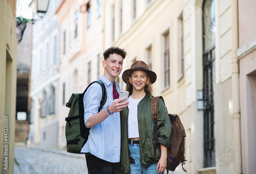 Young couple travelers using smartphone in city on holiday, sightseeing. photo