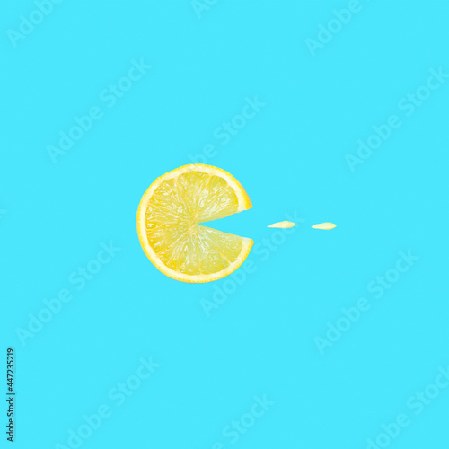 Foto Creative concept photo of a lemon slice eating flower petals on blue background