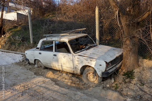 Old broken down soviet-style car by a tree