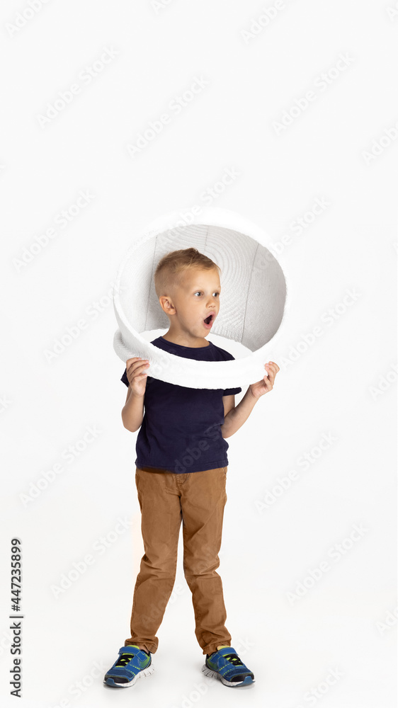 One preschool boy standing isolated on white studio background. Copyspace for ad. Childhood, education, emotion concept. Little astronaut One preschool boy standing isolated on white studio background. Copyspace for ad. Childhood, education, emotion concept. Little astronaut