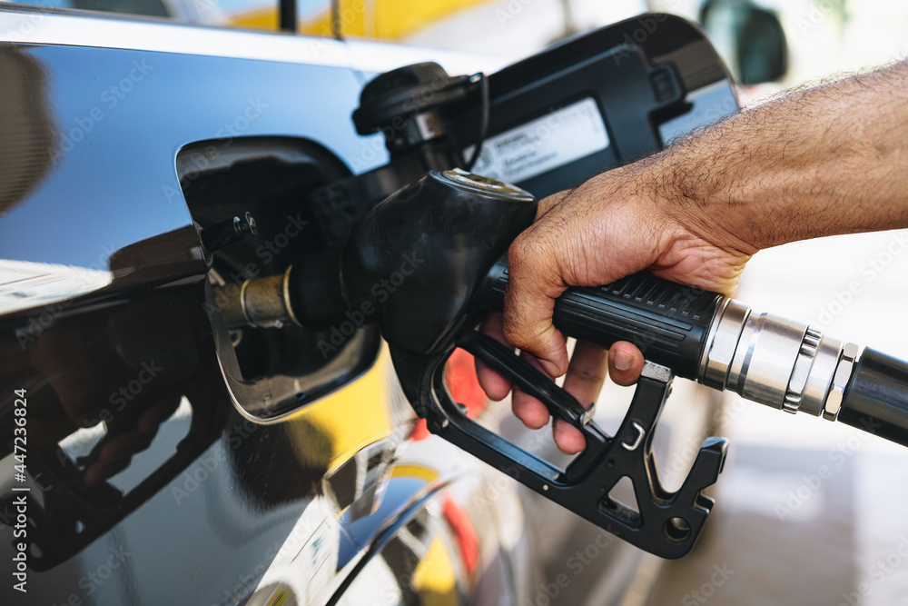 Man filling gasoline fuel in car at gas station Man filling gasoline fuel in car at gas station