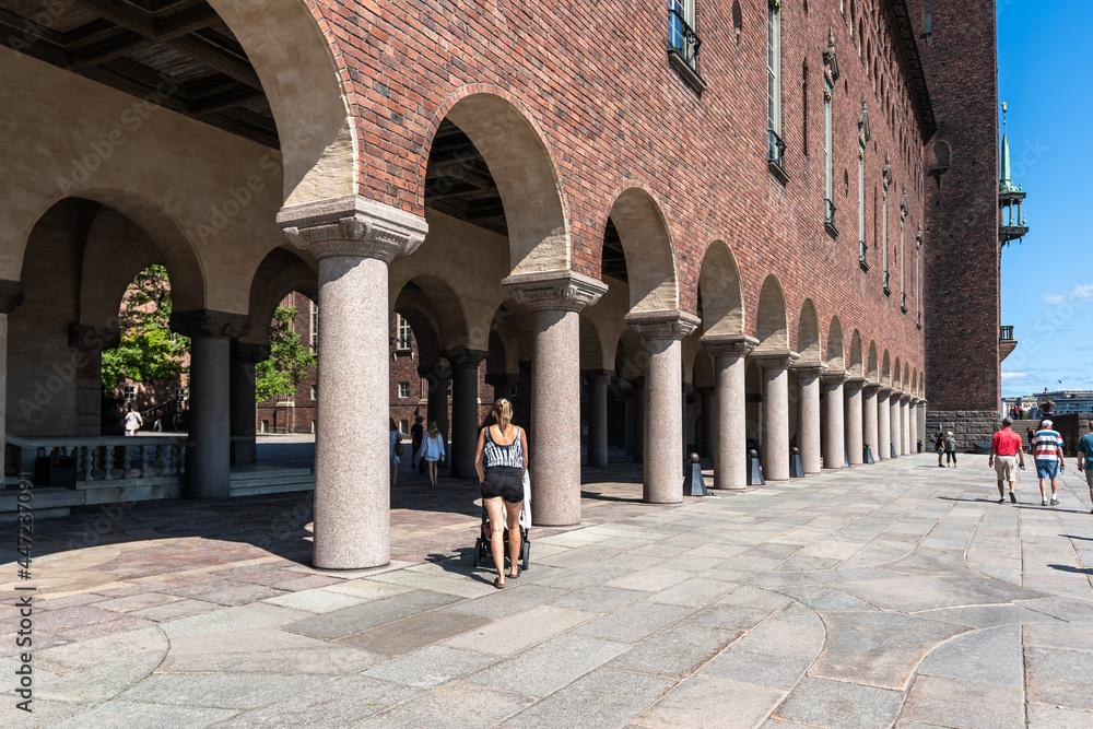 Stockholm City Hall building. Ancient architecture. Columns gallery. People tourists travel around the capital of Sweden on a summer day.