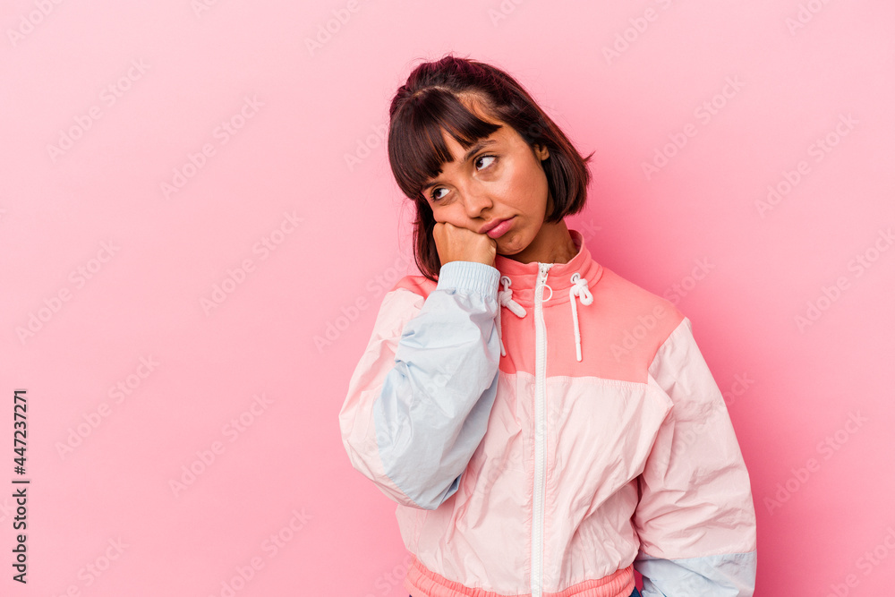 Young mixed race woman isolated on pink background who feels sad and pensive, looking at copy space. Young mixed race woman isolated on pink background who feels sad and pensive, looking at copy space.
