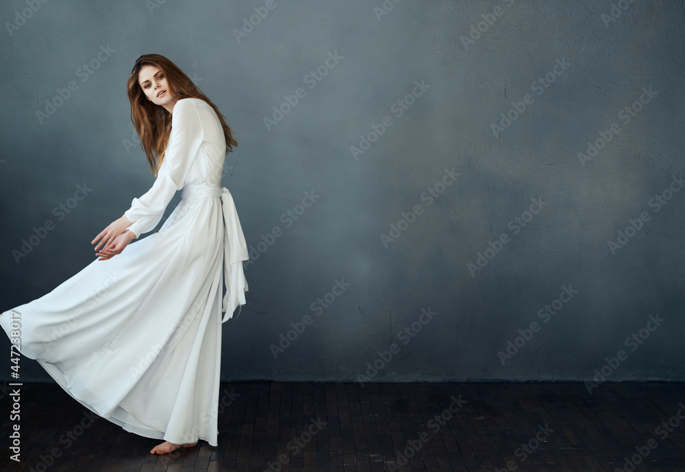 Fototapeta premium elegant woman in white dress dark background posing performance