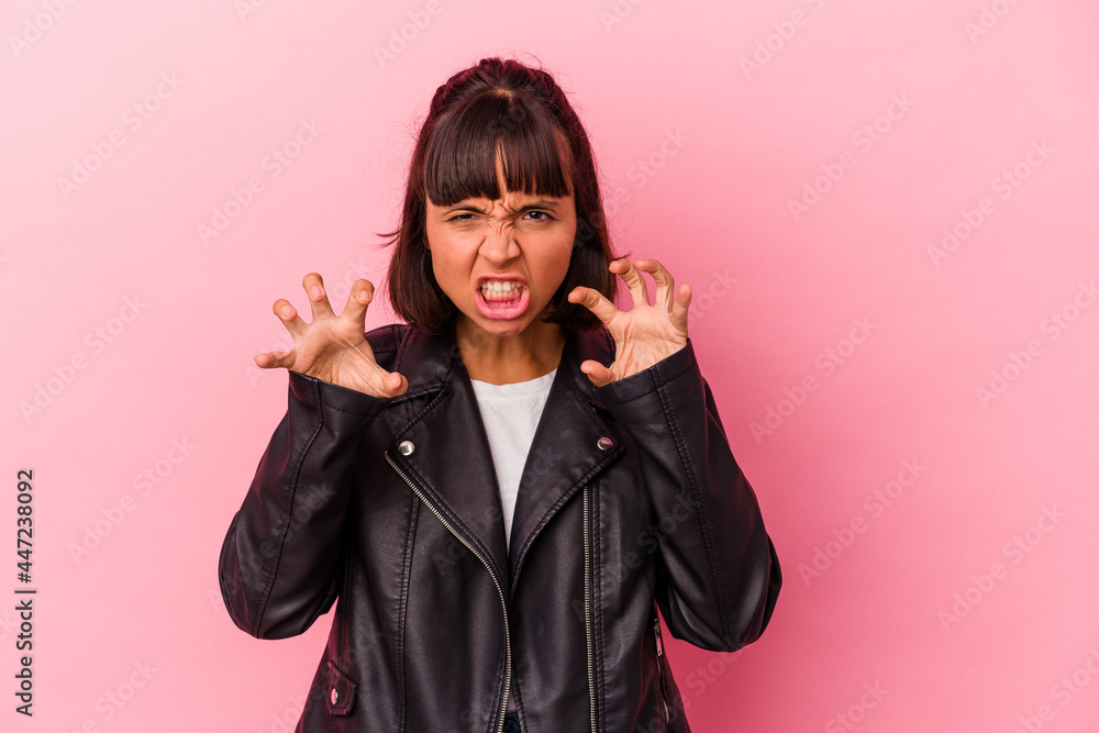 Young mixed race woman isolated on pink background showing claws imitating a cat, aggressive gesture. Young mixed race woman isolated on pink background showing claws imitating a cat, aggressive gesture.