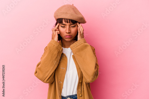 Young mixed race woman isolated on pink background touching temples and having headache.