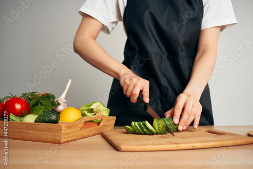 housewife in the kitchen cuts vegetables for salad healthy food