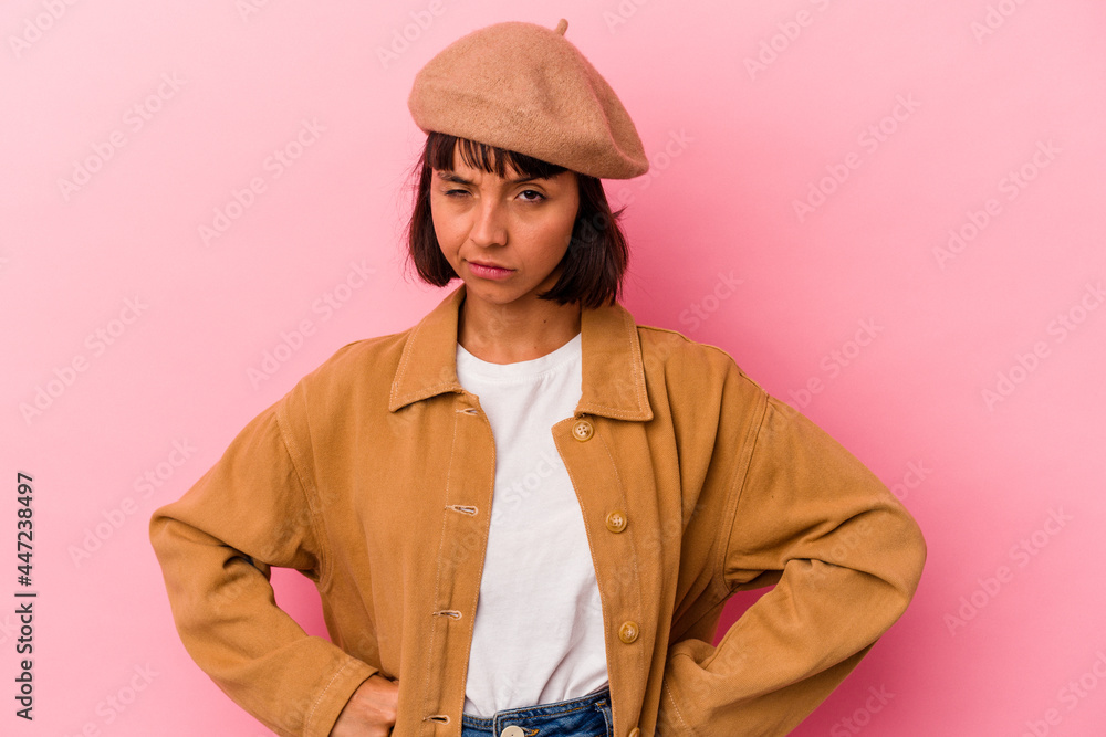 Young mixed race woman isolated on pink background frowning face in displeasure, keeps arms folded. Young mixed race woman isolated on pink background frowning face in displeasure, keeps arms folded.