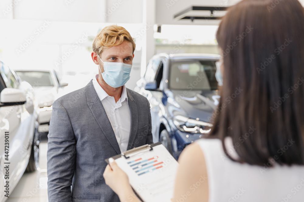 Man customer client buyer in classic suit pandemic mask choose auto want buy new car automobile consult with salesman read documents in showroom salon dealership store motor show indoor Sale concept. Man customer client buyer in classic suit pandemic mask choose auto want buy new car automobile consult with salesman read documents in showroom salon dealership store motor show indoor Sale concept.