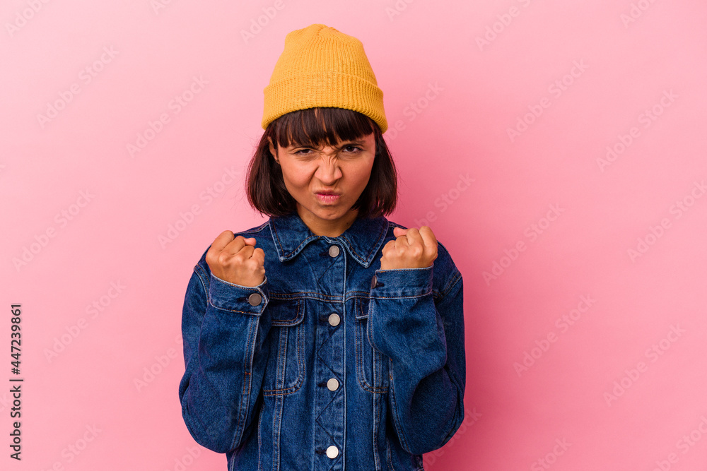 Young mixed race woman isolated on pink background showing fist to camera, aggressive facial expression. Young mixed race woman isolated on pink background showing fist to camera, aggressive facial expression.