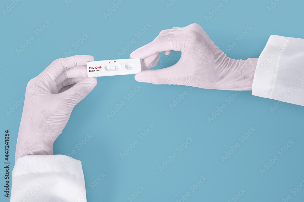 Scientist hands showing rapid laboratory COVID-19 test for diagnosis Positive test result for the new rapidly spreading Coronavirus Covid-19 on blue background Pandemic infectious concept Scientist hands showing rapid laboratory COVID-19 test for diagnosis Positive test result for the new rapidly spreading Coronavirus Covid-19 on blue background Pandemic infectious concept