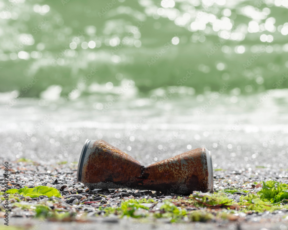 Pollution sea beach with metal waste. Rusty aluminum can on seashore discarded by wave. Garbage, trash polluting water nature and World ocean. Recycle, reuse of aluminum. Square background, copy space Pollution sea beach with metal waste. Rusty aluminum can on seashore discarded by wave. Garbage, trash polluting water nature and World ocean. Recycle, reuse of aluminum. Square background, copy space