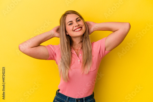 Young russian woman isolated on yellow background stretching arms, relaxed position.