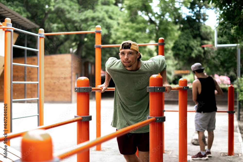 Fototapeta premium male person doing sport exercise on the parallel bars