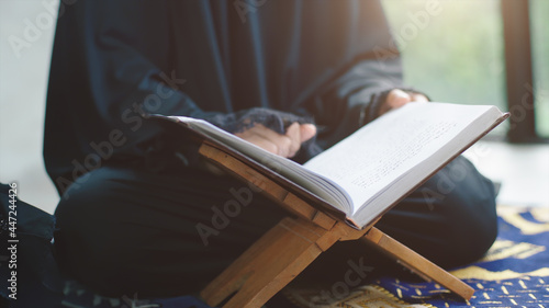 Portrait of an Asian Muslim women in a daily prayer at home reciting Surah al-Fatiha passage of the Qur'an in a single act of Sujud called a Sajdah or prostration photo