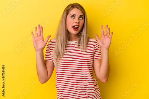 Young russian woman isolated on yellow background screaming to the sky, looking up, frustrated.