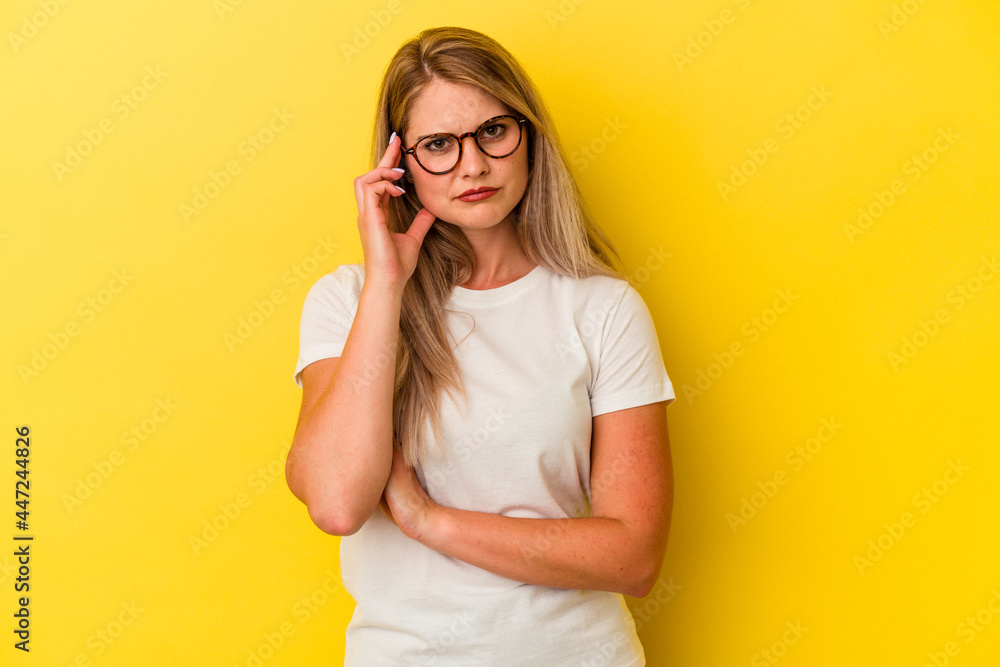 Young russian woman isolated on yellow background blows cheeks, has tired expression. Facial expression concept. Young russian woman isolated on yellow background blows cheeks, has tired expression. Facial expression concept.