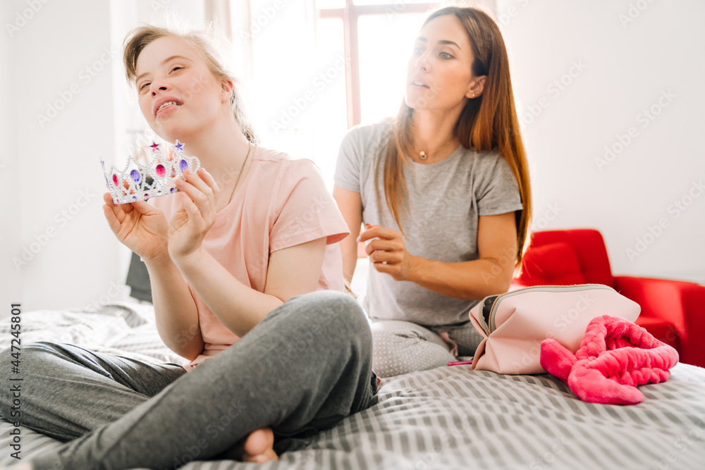 Obraz premium White woman and her daughter with down syndrome sitting on bad