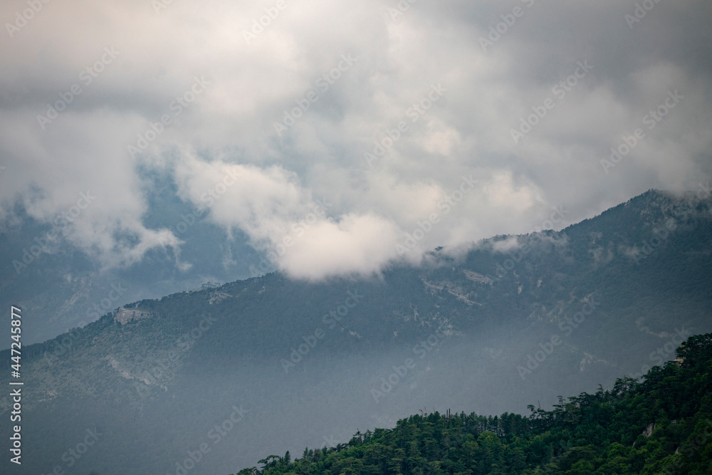 Fototapeta premium heavy huge rainy clouds sky, above the mountain settlement village