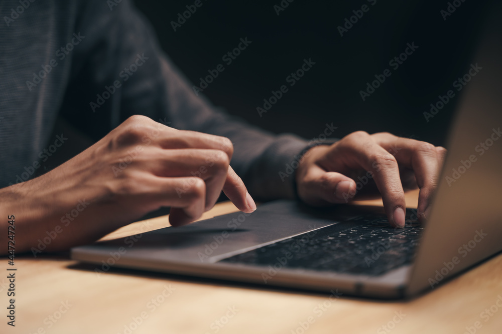 Closeup of a man using a laptop computer on the wooden table, searching, browsing, social media, message, email, internet digital marketing, online shopping.. Closeup of a man using a laptop computer on the wooden table, searching, browsing, social media, message, email, internet digital marketing, online shopping..