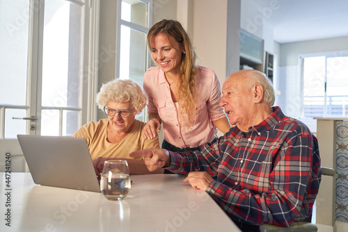 Curious senior couple with daughter on laptop computer