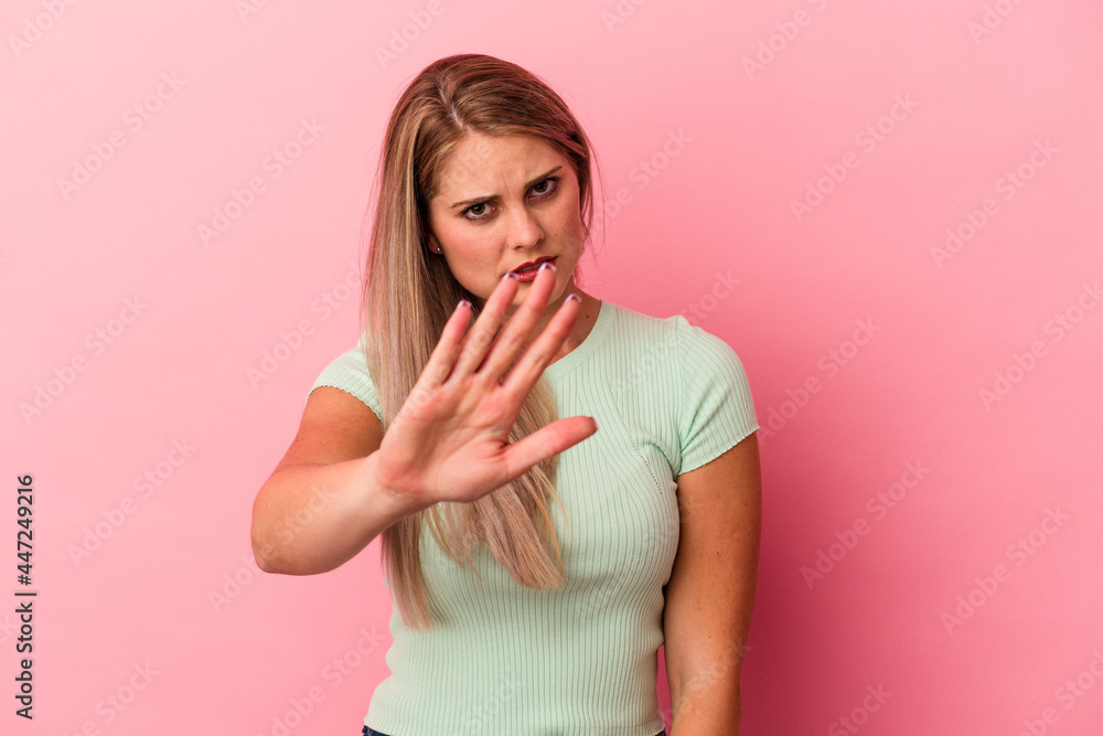 Young russian woman isolated on pink background rejecting someone showing a gesture of disgust. Young russian woman isolated on pink background rejecting someone showing a gesture of disgust.