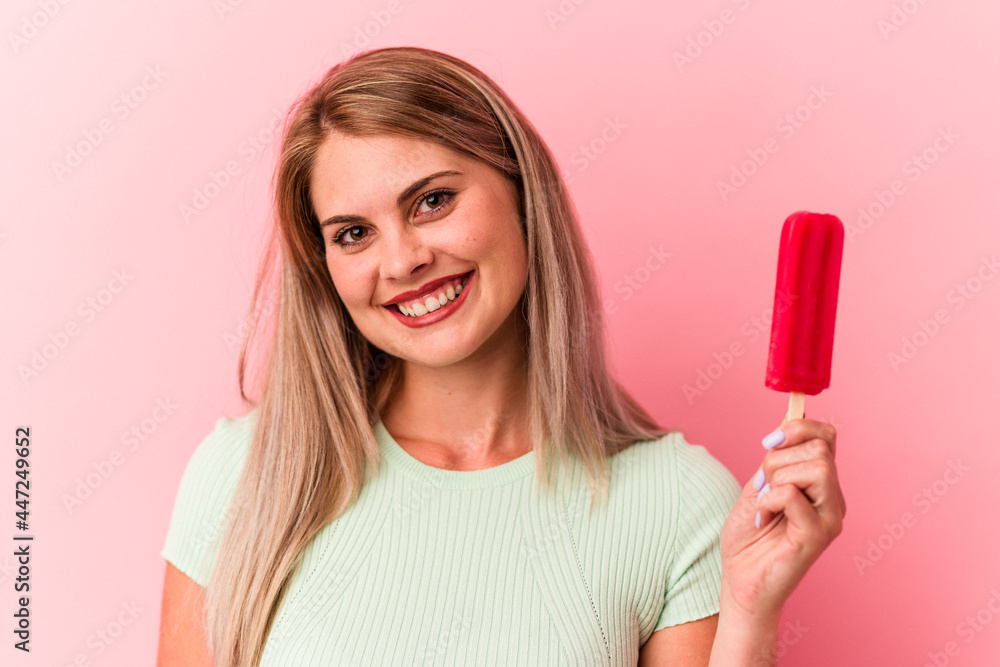 Young russian woman holding an ice cream isolated on pink background