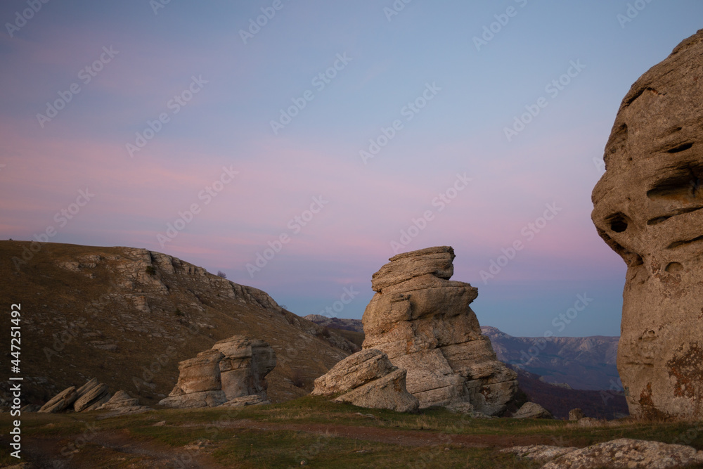 Evening mountain landscape, sunset purple sky between large boulders.
