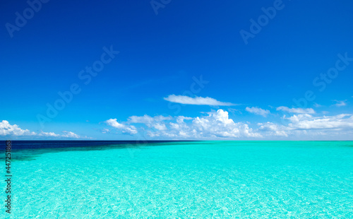 clouds on blue sky over calm sea with sunlight reflection