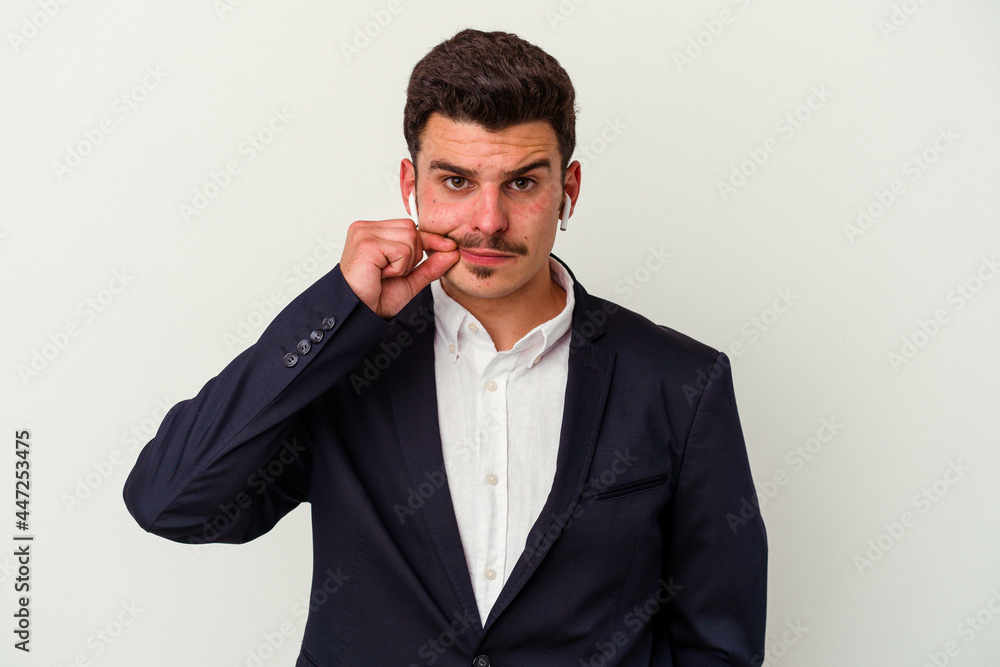 Young business caucasian man wearing wireless headphones isolated on white background with fingers on lips keeping a secret. Young business caucasian man wearing wireless headphones isolated on white background with fingers on lips keeping a secret.