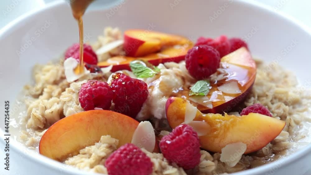 Summer oatmeal with raspberries, peaches and nuts. Cooking healthy vegetarian food concept.