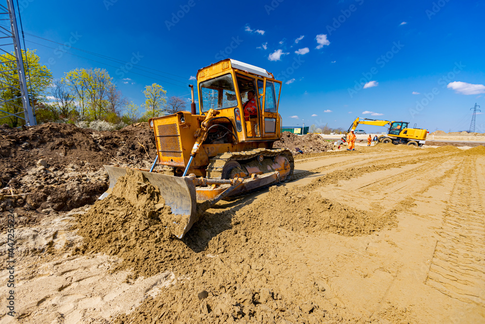 Obraz premium Bulldozer machine is leveling construction site.