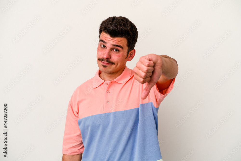 Young caucasian man isolated on white background showing thumb down, disappointment concept. Young caucasian man isolated on white background showing thumb down, disappointment concept.