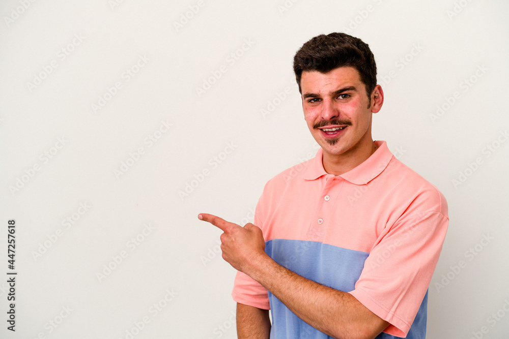 Young caucasian man isolated on white background smiling and pointing aside, showing something at blank space. Young caucasian man isolated on white background smiling and pointing aside, showing something at blank space.
