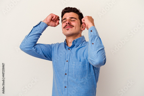 Young caucasian man isolated on white background celebrating a special day, jumps and raise arms with energy.