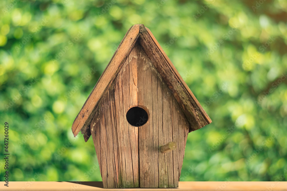 Wooden bird house on green nature background