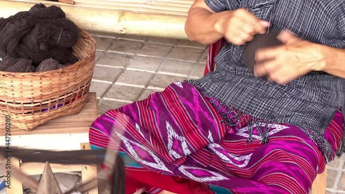 Woman Karen Tribal rolling a ball of brown dyed thread in preparation for hand weaving traditional clothing and crafts photo