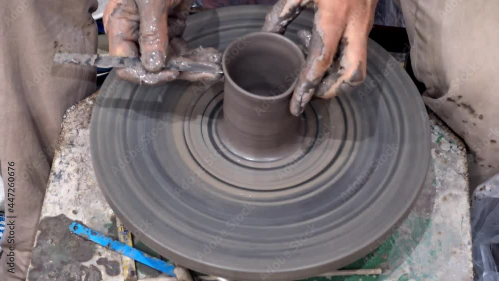 Traditional pottery making, close-up of potter's hands shaping a vase on the spinning by clay. Traditional pottery making, close-up of potter's hands shaping a vase on the spinning by clay.