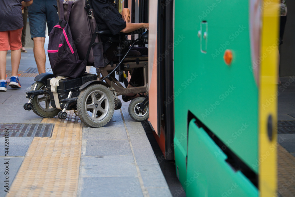 handicapped person getting into a wheelchair on the metro. The photo